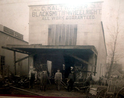 Photo of Deanville Blacksmith, John Maresh Jr. (Center) in training under C. Kaltwasser Blacksmith and Wheelwright